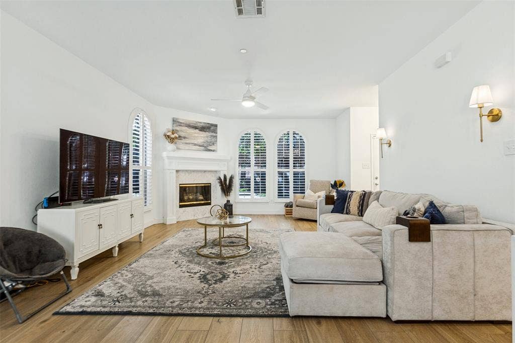 6816 Livorno Lane, Frisco, TX 75034 Wood-finish flooring throughout, white walls, and arched windows with shutters