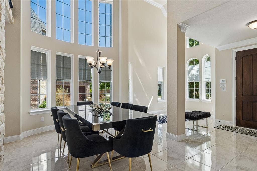 3613 Sparkling Drive, Plano, TX 75074 Two-story ceiling, multiple large windows, tile flooring, stone accent wall, and a solid wood entry door