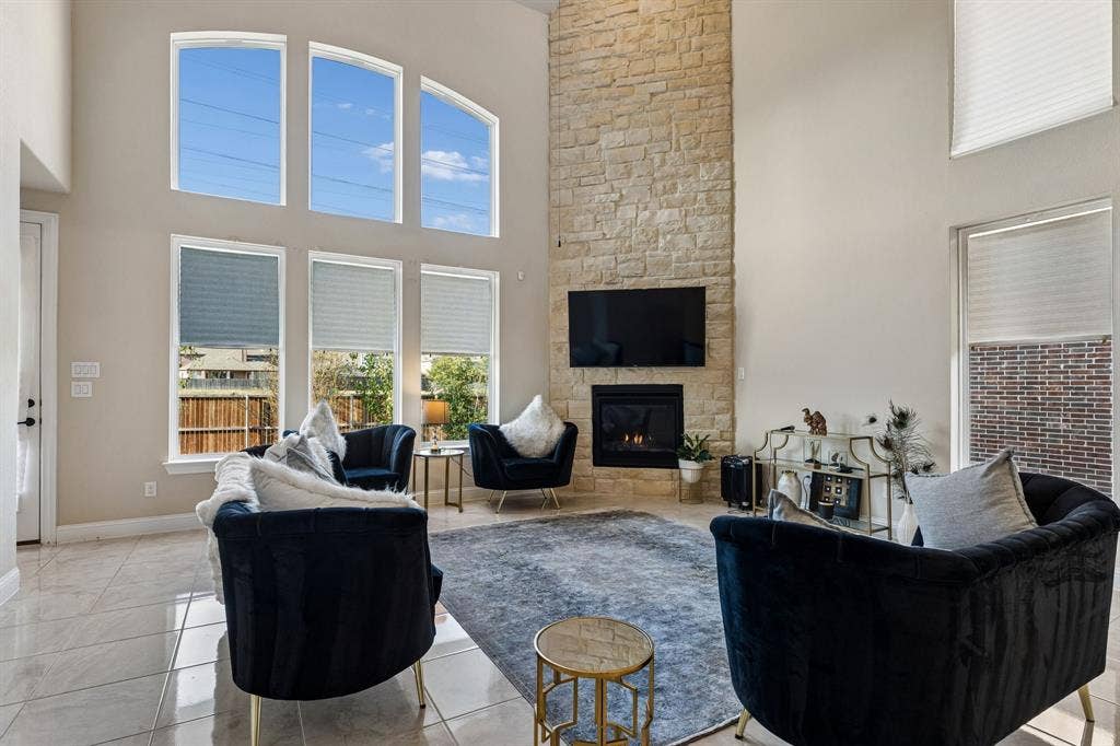 3613 Sparkling Drive, Plano, TX 75074 Living area with soaring ceilings, a stone-clad fireplace, and an integrated media wall