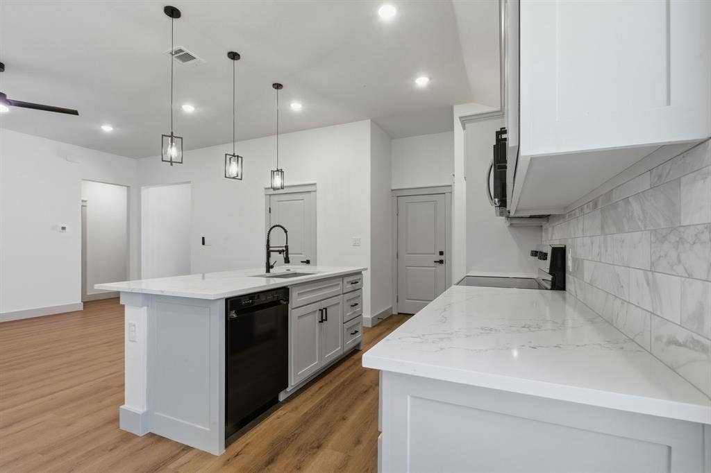 14583 Cherokee Lane, Log Cabin, TX 75148 Kitchen featuring a large island with sink, white countertops, built-in dishwasher, light gray cabinetry, and a white subway tile backsplash