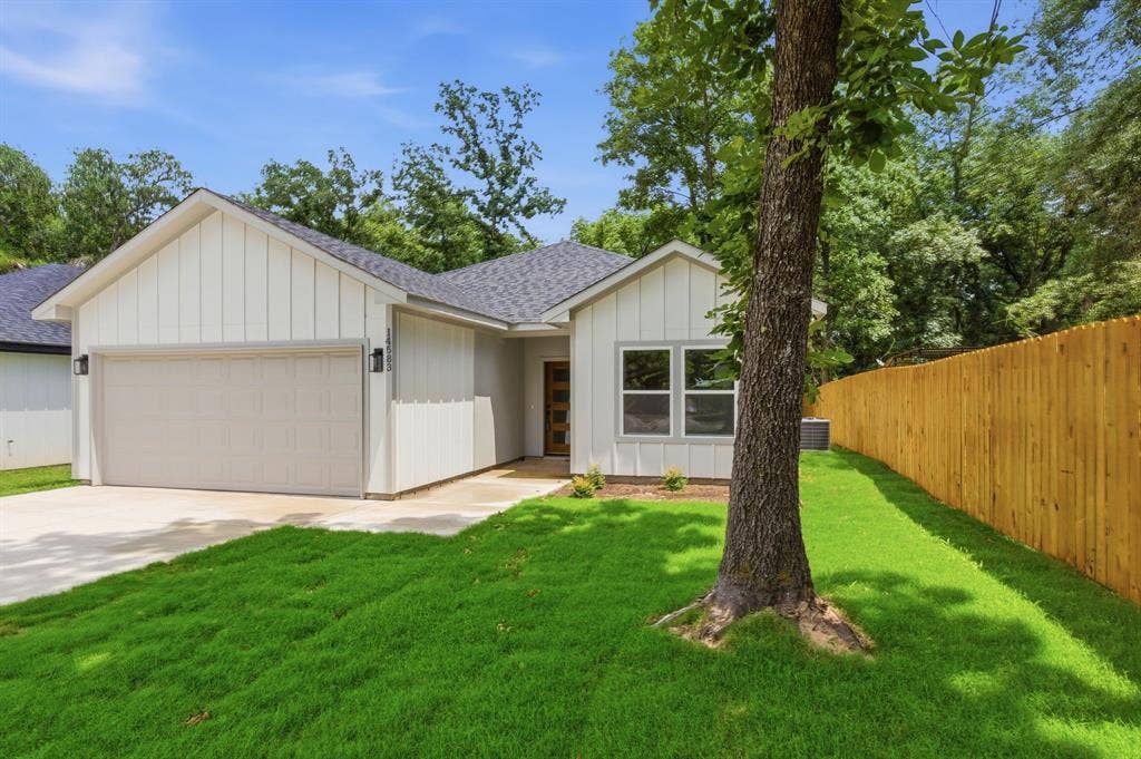 14583 Cherokee Lane, Log Cabin, TX 75148 Contemporary exterior featuring vertical siding, a two-car garage, and a charcoal-toned shingle roof