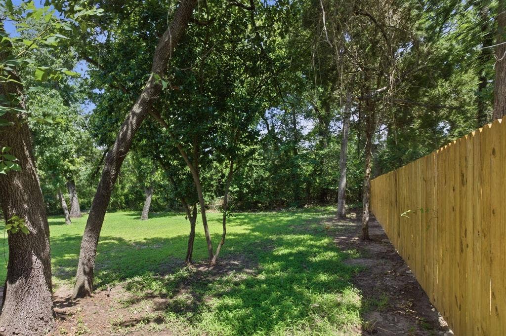 14583 Cherokee Lane, Log Cabin, TX 75148 Grassed outdoor area with mature trees and a wooden privacy fence