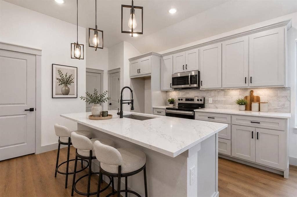 14583 Cherokee Lane, Log Cabin, TX 75148 Virtual image Kitchen featuring an island with a stone countertop and an undermount sink, pendant lighting, light-toned cabinetry with dark hardware, a subway tile backsplash, and wood-finish flooring