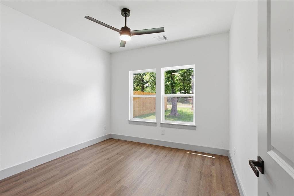 14583 Cherokee Lane, Log Cabin, TX 75148 Bright interior space featuring wood-finish flooring, a modern ceiling fan, and two windows