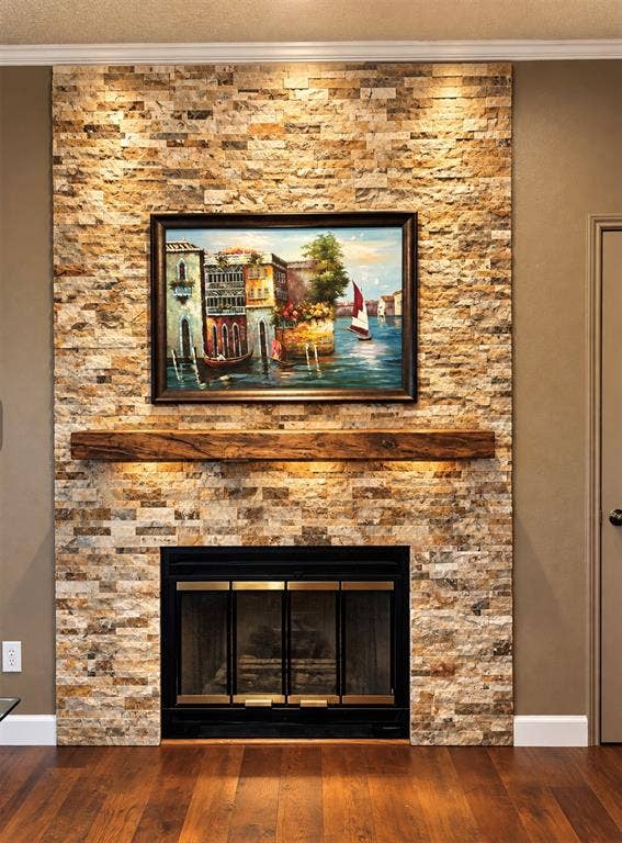 Stone veneer fireplace with a rustic wood mantel, integrated fireplace insert, and rich wood-finish flooring