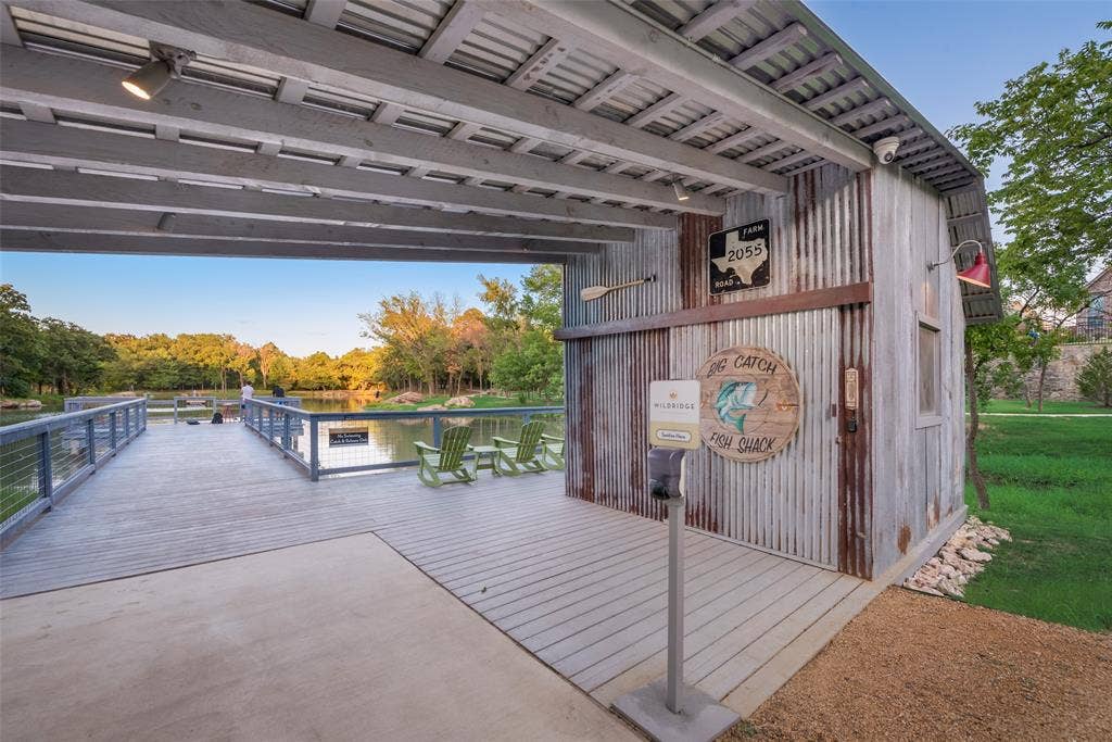 Expansive covered dock with corrugated metal siding, wood-finish decking, and a built-in outdoor lighting fixture