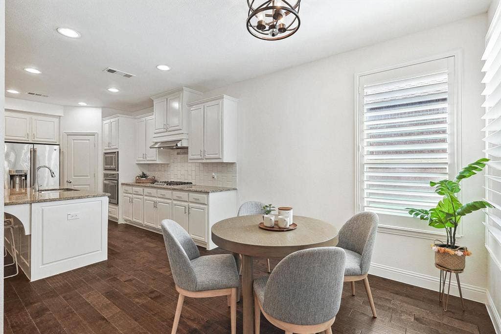 Kitchen featuring white cabinetry, stainless steel appliances, recessed lighting, wood-finish flooring, and a window with plantation shutters