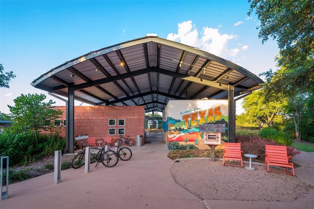 Open-air structure with a metal roof, brick accent wall, and integrated lighting