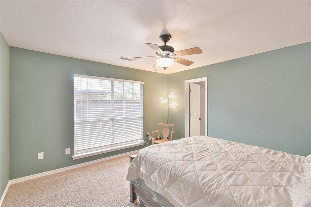 2108 8th Street, Brownwood, TX 76801 Recessed ceiling, neutral carpet, large window with blinds, ceiling fan with integrated lighting, and a white door frame