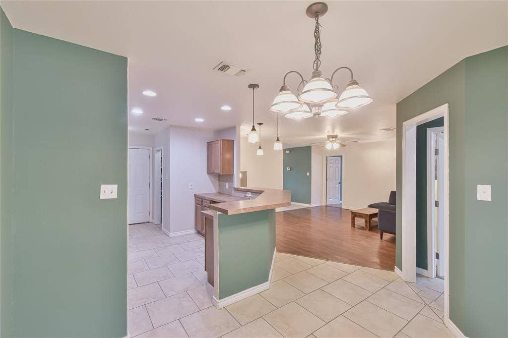 2108 8th Street, Brownwood, TX 76801 Open concept living space featuring a breakfast bar, recessed lighting, and a multi-light chandelier