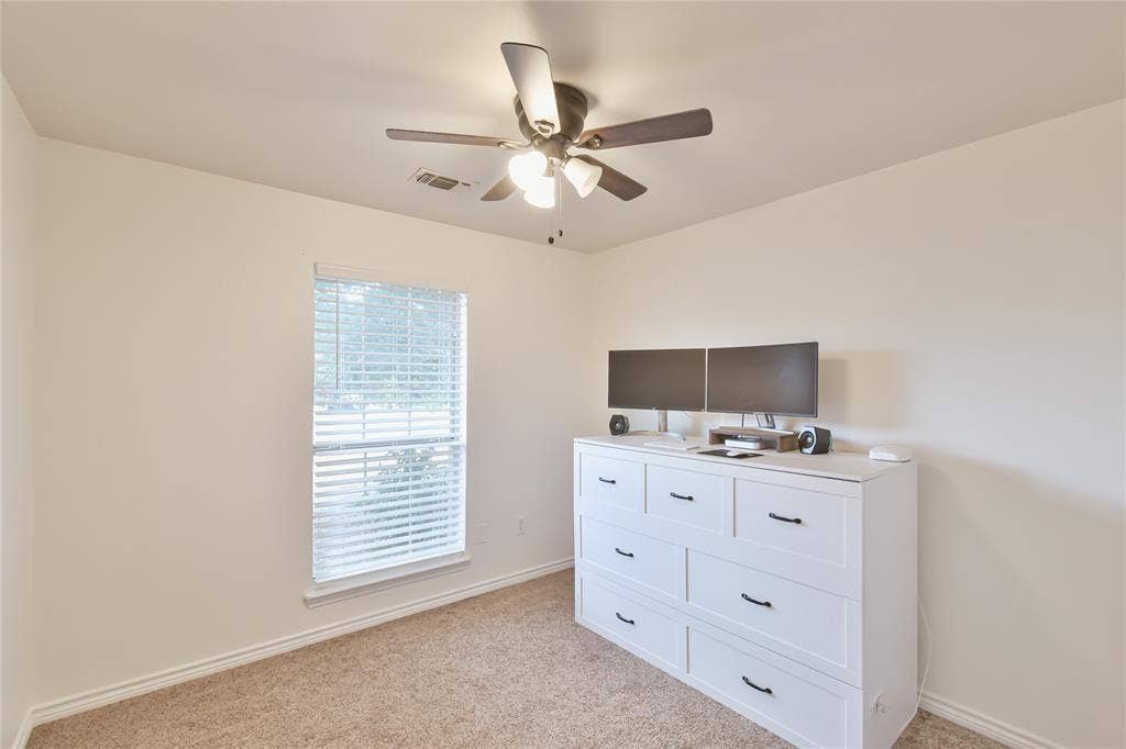 2108 8th Street, Brownwood, TX 76801 Neutral wall color, ceiling fan with integrated lighting, window with horizontal blinds, and carpeted flooring