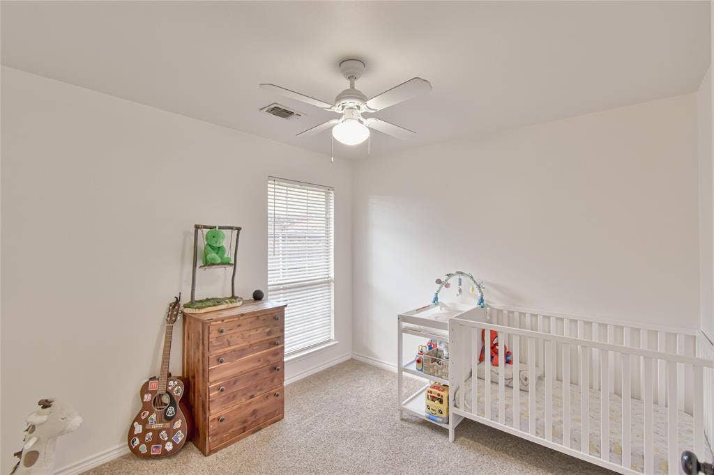 2108 8th Street, Brownwood, TX 76801 Carpeted room featuring a ceiling fan with light, a window with blinds, and white painted walls