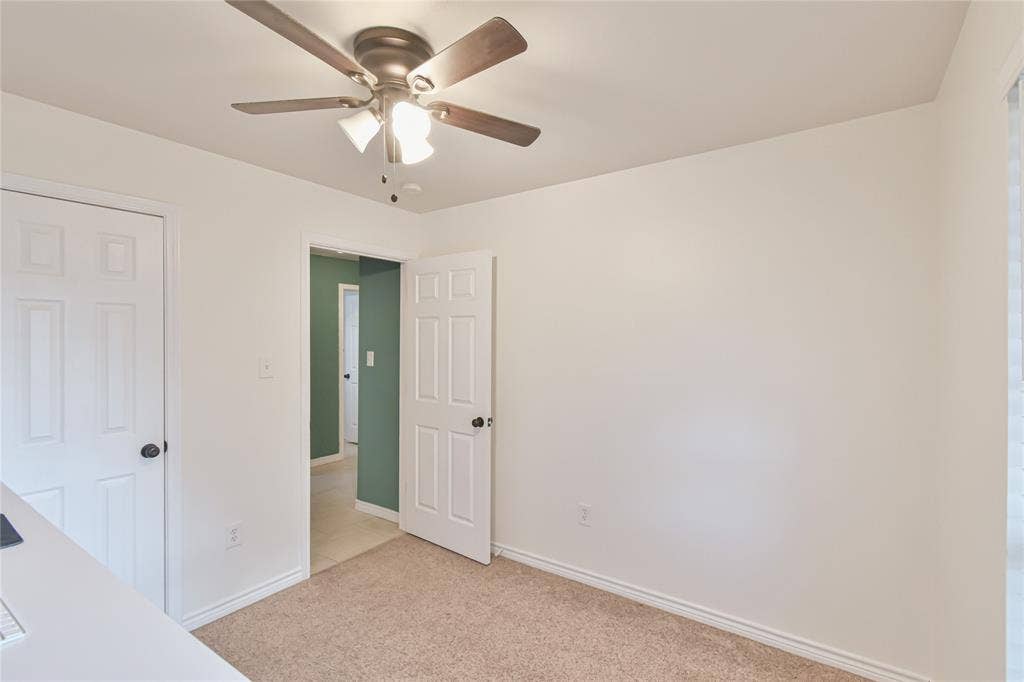 2108 8th Street, Brownwood, TX 76801 Recessed panel doors, ceiling fan with integrated lighting, and neutral carpeting