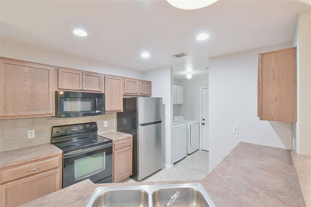 2108 8th Street, Brownwood, TX 76801 Kitchen featuring wood-finish cabinetry, stainless steel appliances, and a double basin sink