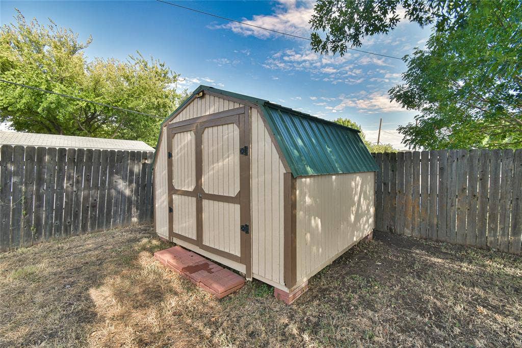 2108 8th Street, Brownwood, TX 76801 Storage shed featuring a gambrel roof and double doors