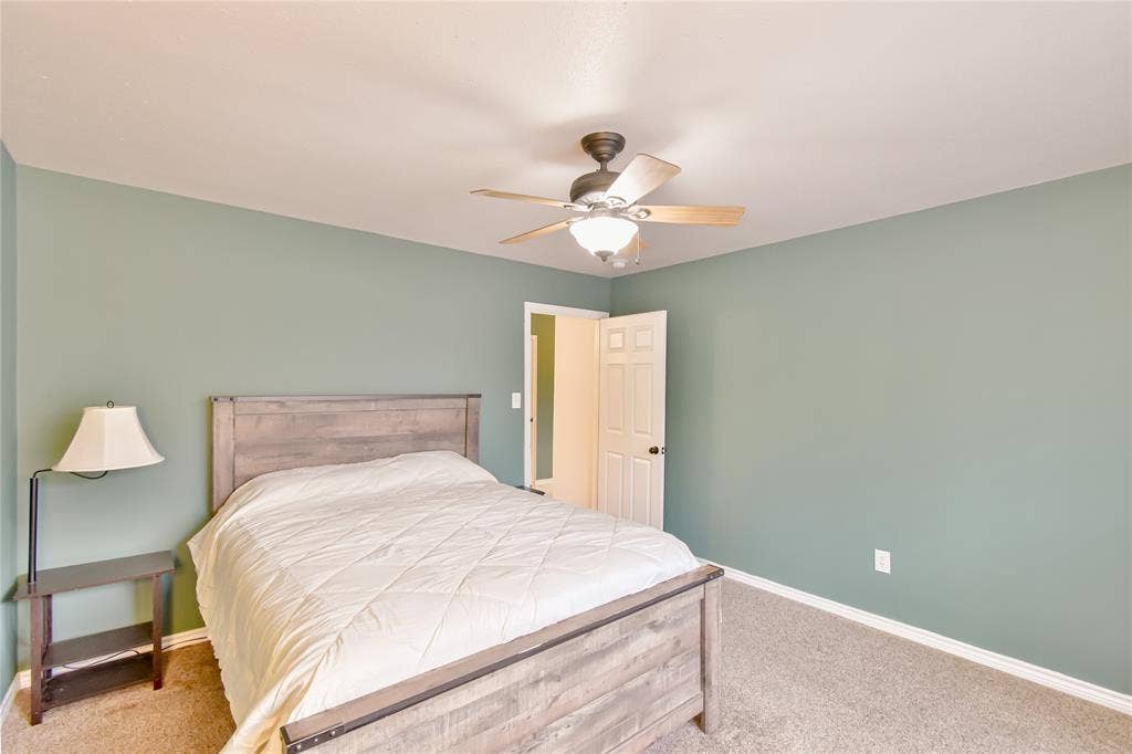 2108 8th Street, Brownwood, TX 76801 Light gray-green wall paint, carpet flooring, white trim, and a ceiling fan with integrated lighting
