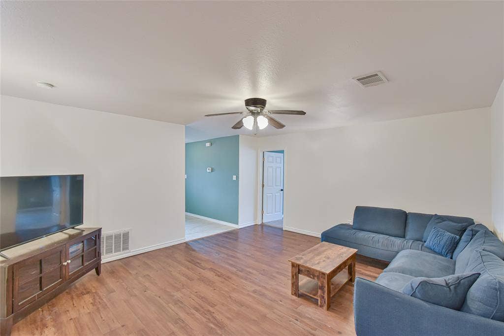 2108 8th Street, Brownwood, TX 76801 Spacious living area featuring wood-finish flooring, a ceiling fan, and recessed lighting