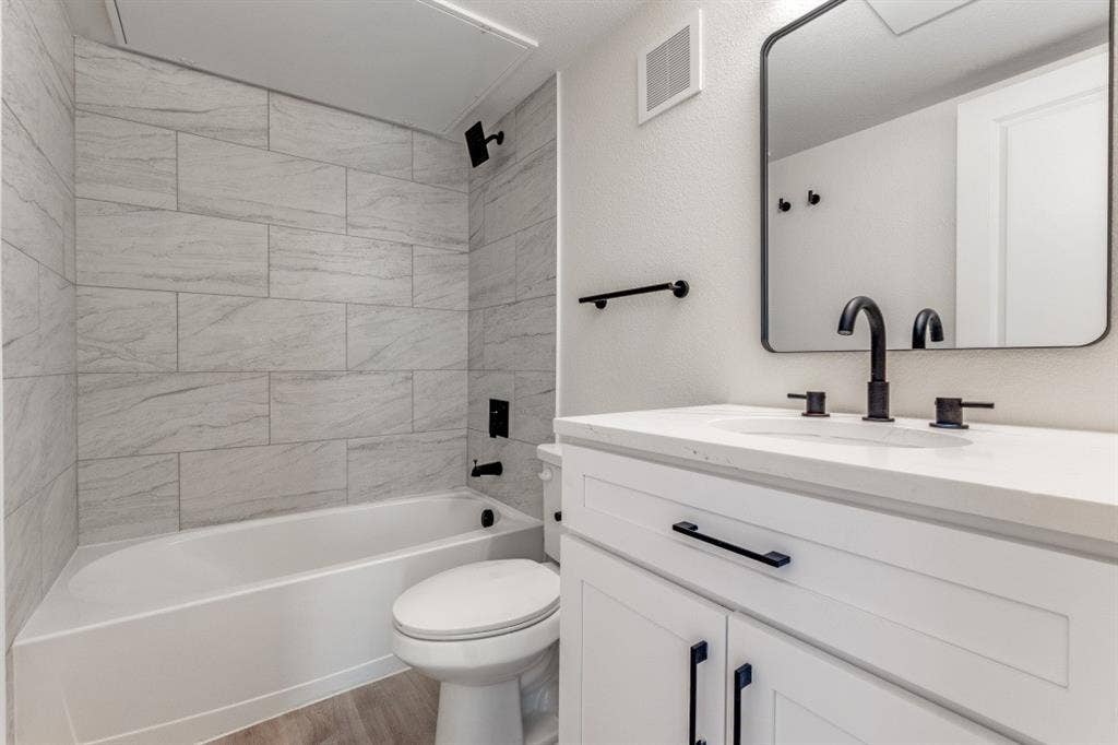 5917 Gaston Avenue, #115, Dallas, TX 75214 White vanity with shaker-style cabinetry, a single basin sink, and matte black fixtures