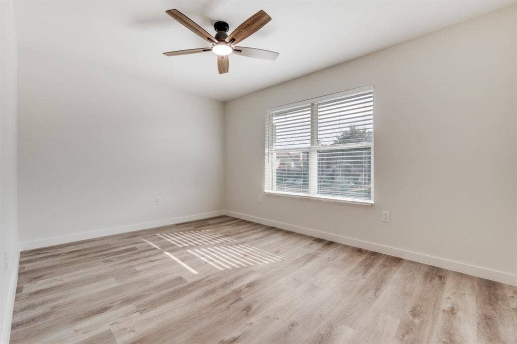 5917 Gaston Avenue, #115, Dallas, TX 75214 Wood-finish flooring, ceiling fan with integrated lighting, and a window with blinds
