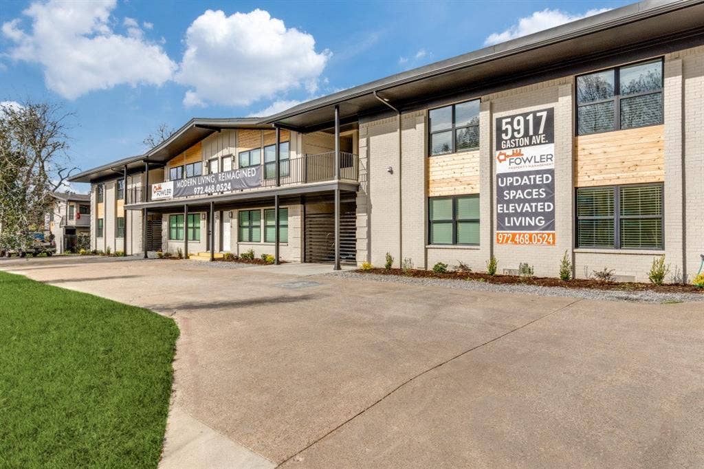 5917 Gaston Avenue, #115, Dallas, TX 75214 Contemporary building with a light brick facade, wood-finish accents, large windows, and a metal-railed balcony
