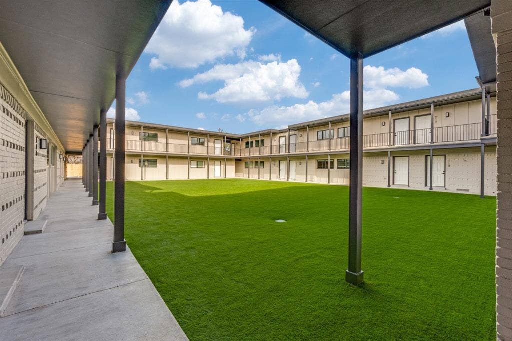 5917 Gaston Avenue, #115, Dallas, TX 75214 Central courtyard with artificial turf, surrounded by multi-story buildings featuring balconies and covered walkways