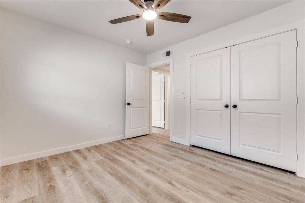 5917 Gaston Avenue, #115, Dallas, TX 75214 Wood-finish flooring, white walls, and a ceiling fan with integrated lighting