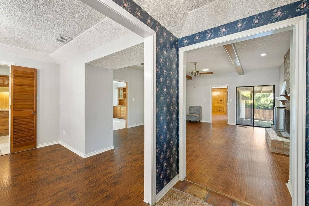 Wood-finish flooring throughout, with a wood louvered sliding door, and a brick fireplace