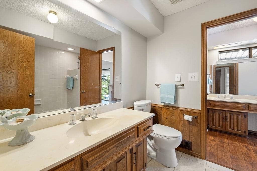 Vanity with an integrated sink, wood cabinetry, and a countertop