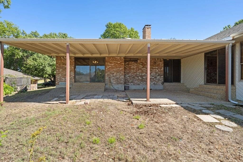Expansive covered patio with brick exterior and dual sliding glass doors