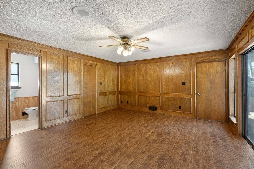 Wood-finish flooring with wood paneling, recessed lighting, and a ceiling fan