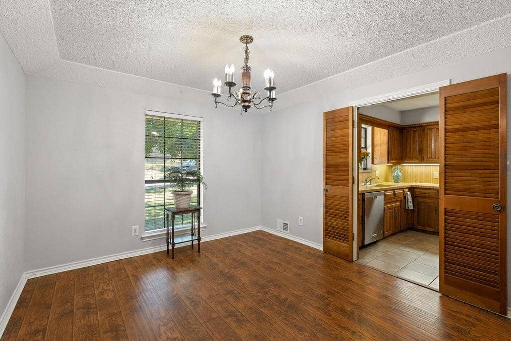 Wood-finish flooring, tray ceiling, and a traditional chandelier