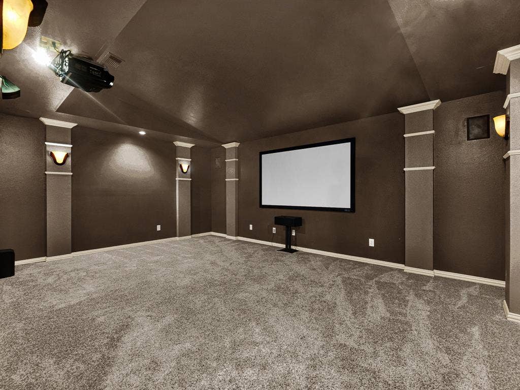 10222 Plainsman Lane, Frisco, TX 75035 Dedicated media room featuring a large projection screen, wall-mounted projector, recessed lighting, and wall sconces