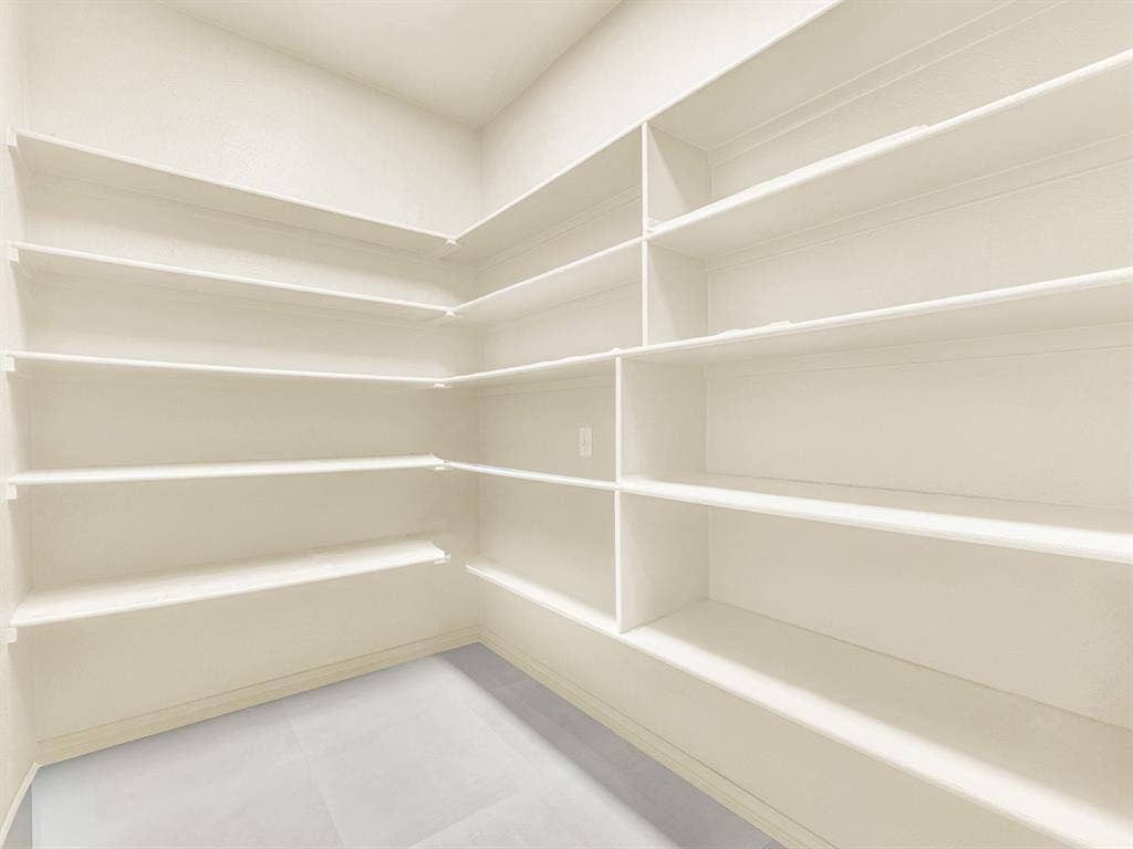 10222 Plainsman Lane, Frisco, TX 75035 Corner pantry featuring extensive shelving, white painted finishes, and light-toned flooring