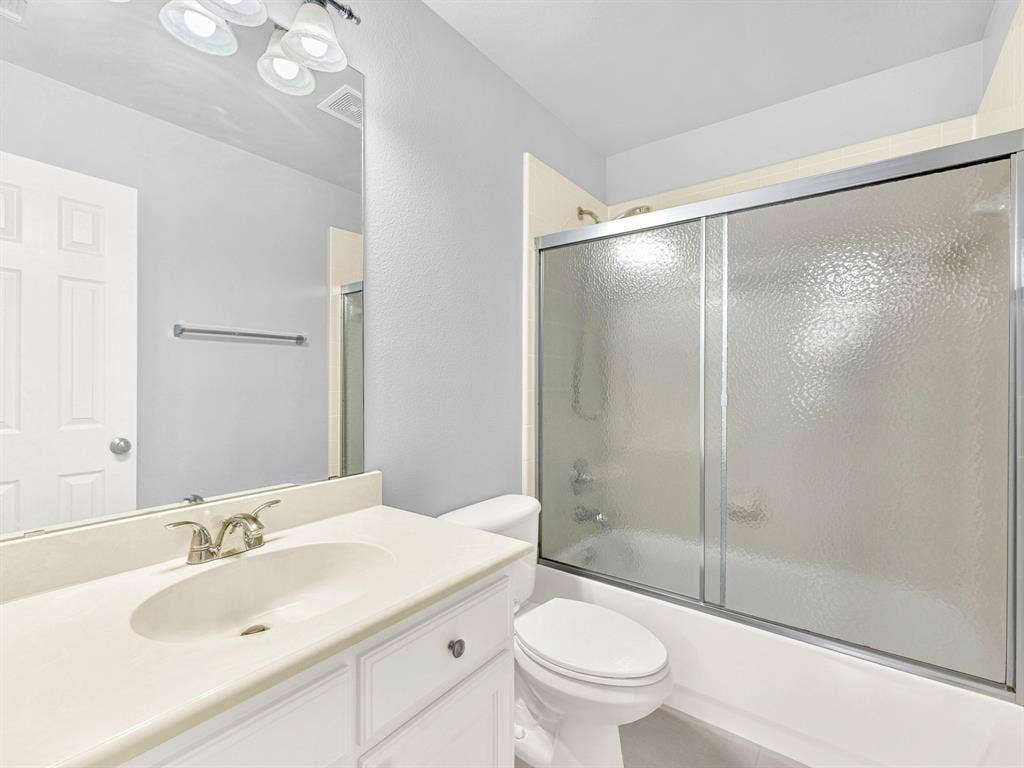 10222 Plainsman Lane, Frisco, TX 75035 White vanity with integrated sink, brushed nickel faucet, large wall-mounted mirror, and overhead vanity lighting