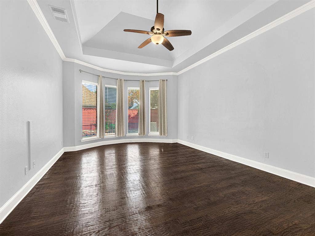 10222 Plainsman Lane, Frisco, TX 75035 Tray ceiling with crown molding, wood-finish flooring, ceiling fan, and bay windows