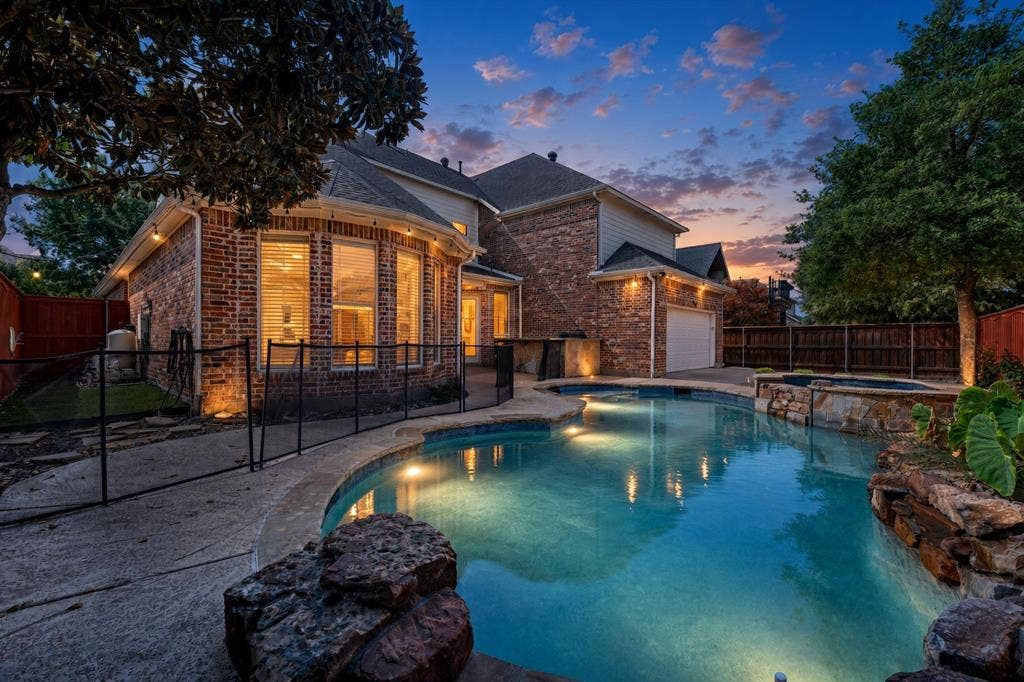 10222 Plainsman Lane, Frisco, TX 75035 Brick exterior with bay windows and a private swimming pool, featuring integrated lighting, a spa, and stone accents