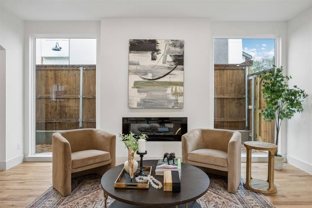 The large picture windows frame the electric fireplace
