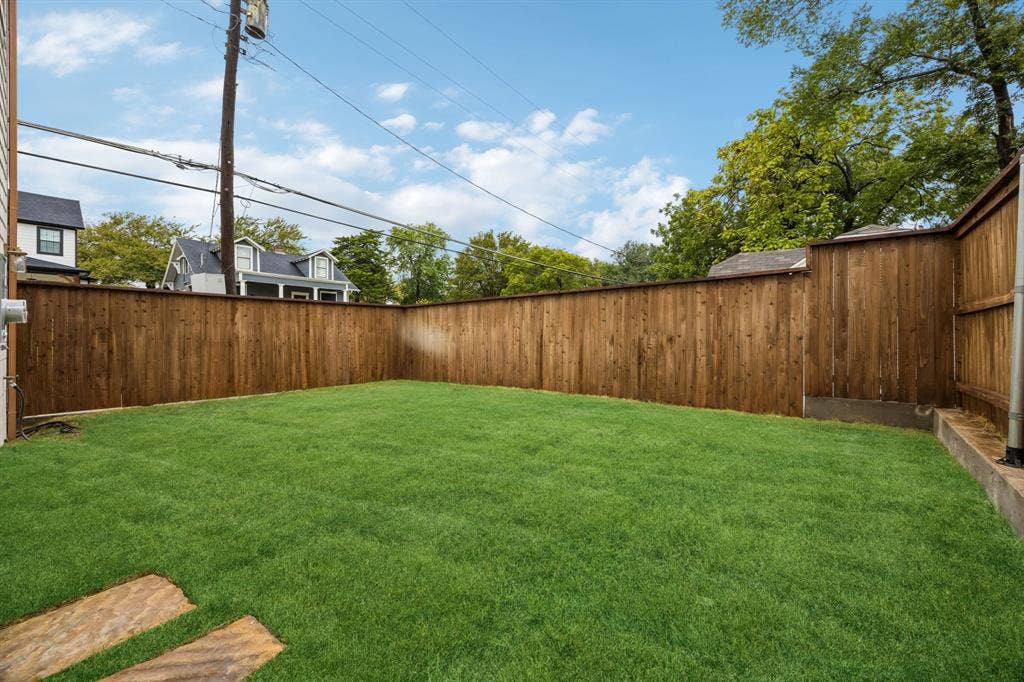 Expansive lawn area with wood privacy fencing and stone paver accents