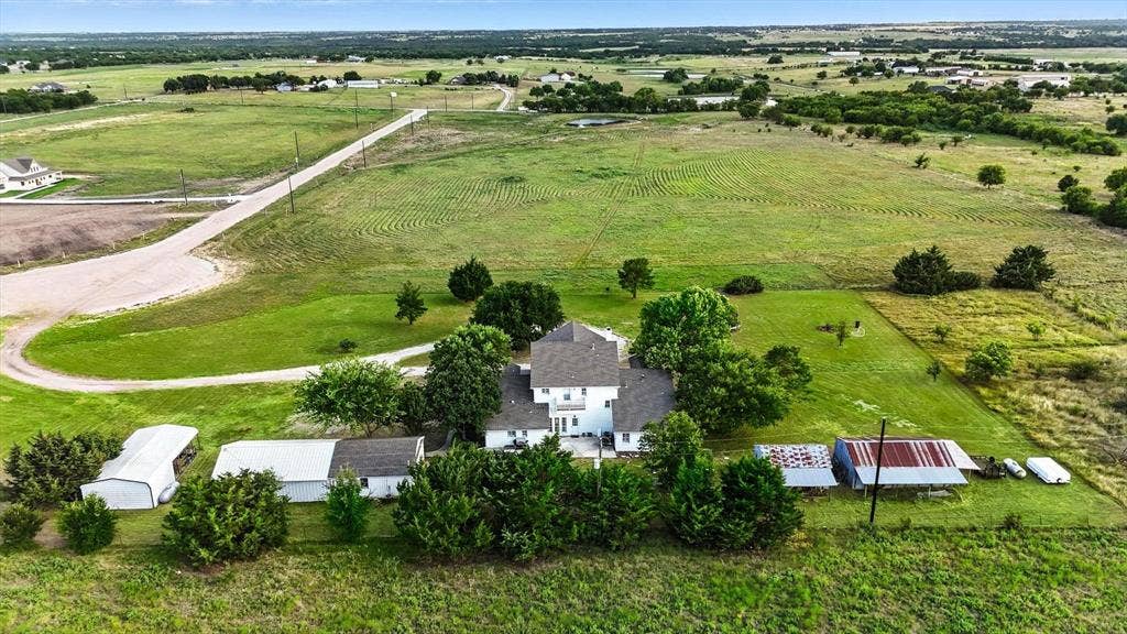 185 Quail Run Court, Decatur, TX 76234 White two-story residence with a dark roof, surrounded by mature trees