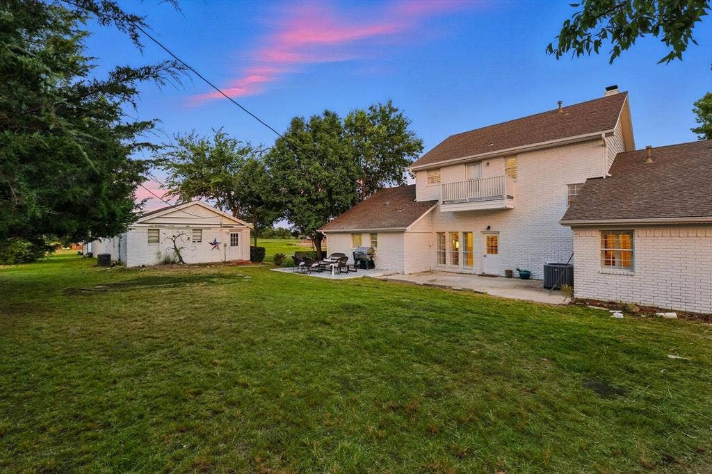 185 Quail Run Court, Decatur, TX 76234 Expansive green lawn with a detached auxiliary building, concrete patio, and upper-level balcony