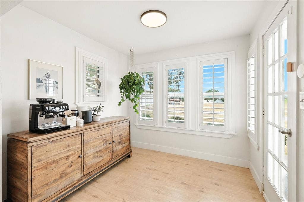 185 Quail Run Court, Decatur, TX 76234 Light wood-finish flooring, white walls, multiple windows with plantation shutters, ceiling-mounted flush light fixture, and a French-style door with glass panels