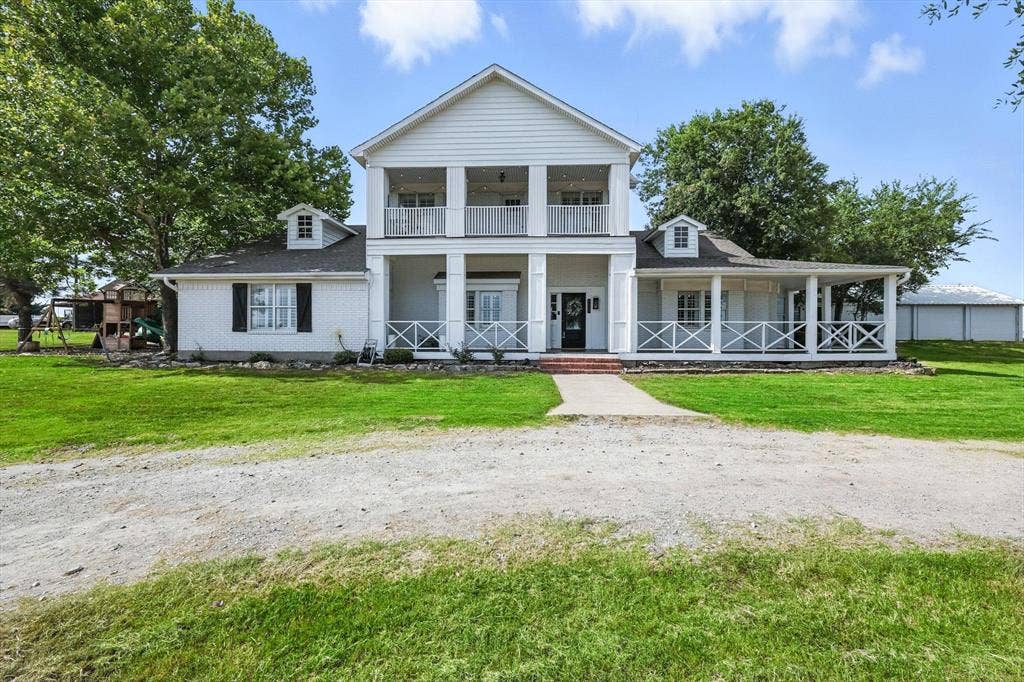 185 Quail Run Court, Decatur, TX 76234 Two-story residence with white siding, a covered front porch, and a second-story balcony