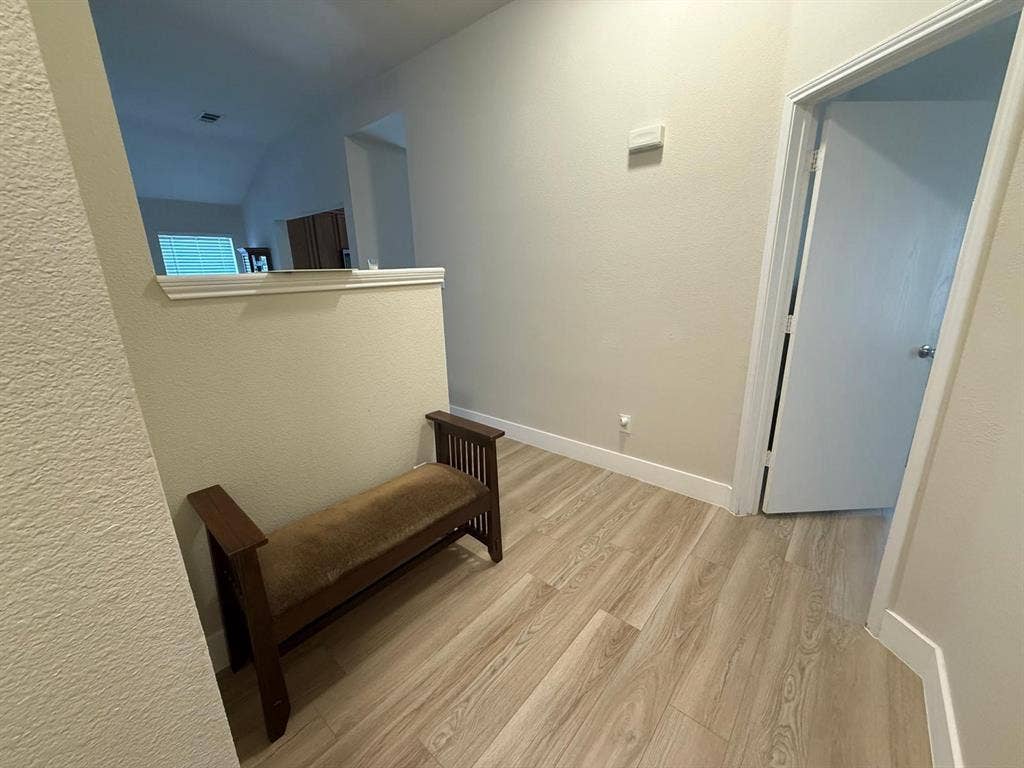 Wood-finish flooring throughout, neutral wall paint, and white trim accents