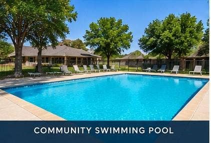 Rectangular swimming pool with a surrounding concrete deck, lined with lounge chairs
