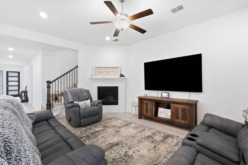 2637 Basswood Drive, Northlake, TX 76226 Living area featuring a fireplace with a mantel, wood-finish flooring, and a ceiling fan