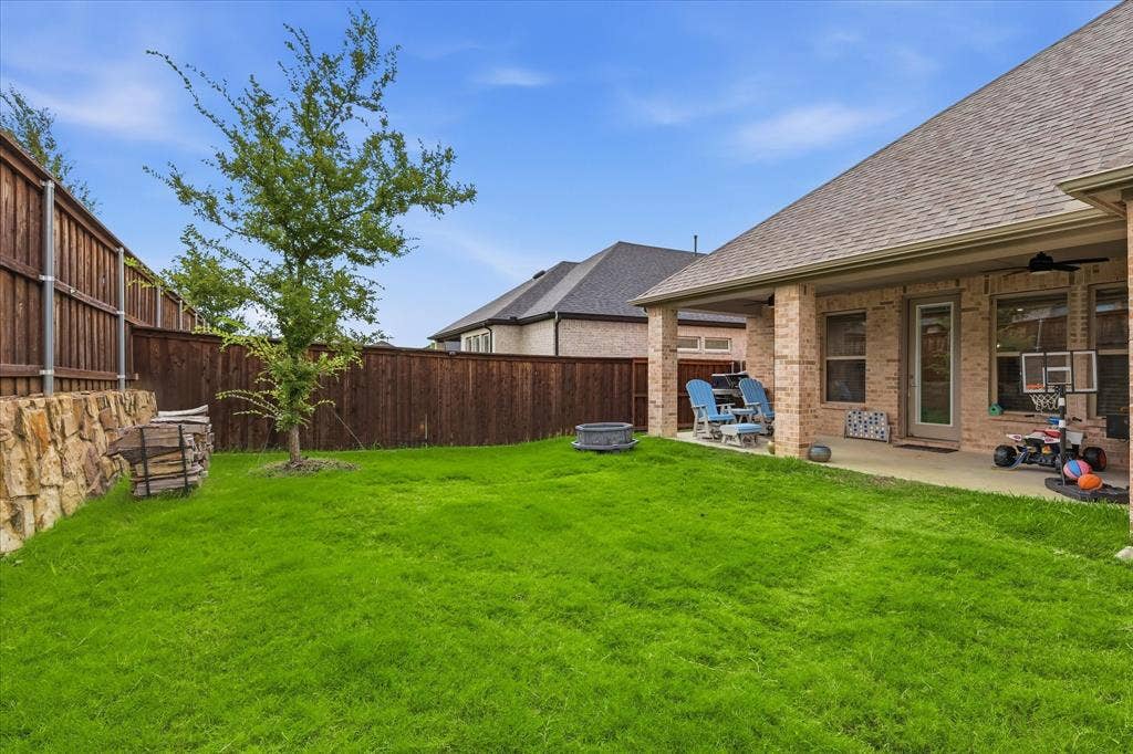 2637 Basswood Drive, Northlake, TX 76226 Expansive grassy lawn with a covered patio featuring a ceiling fan, brick pillars, and a wood privacy fence