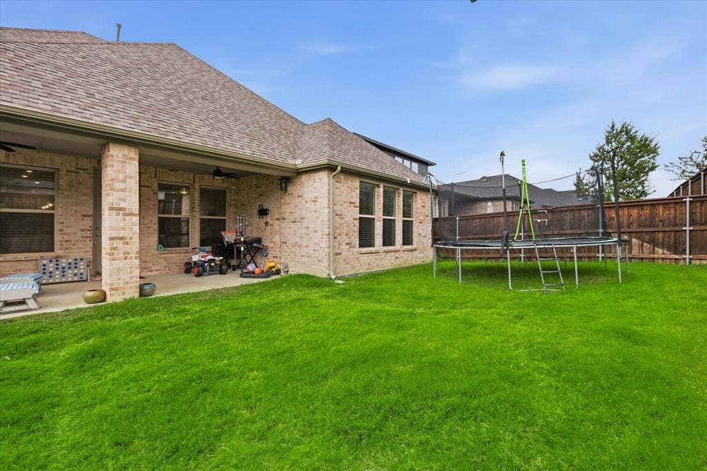 2637 Basswood Drive, Northlake, TX 76226 Expansive green lawn, brick exterior, covered patio, multiple windows, and a privacy fence