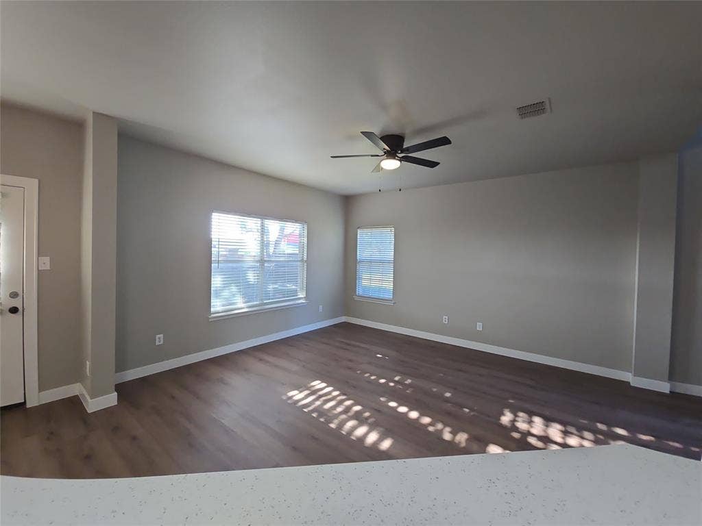 8621 Brunswick Drive, Plano, TX 75024 Spacious interior with wood-finish flooring, neutral paint, and multiple windows