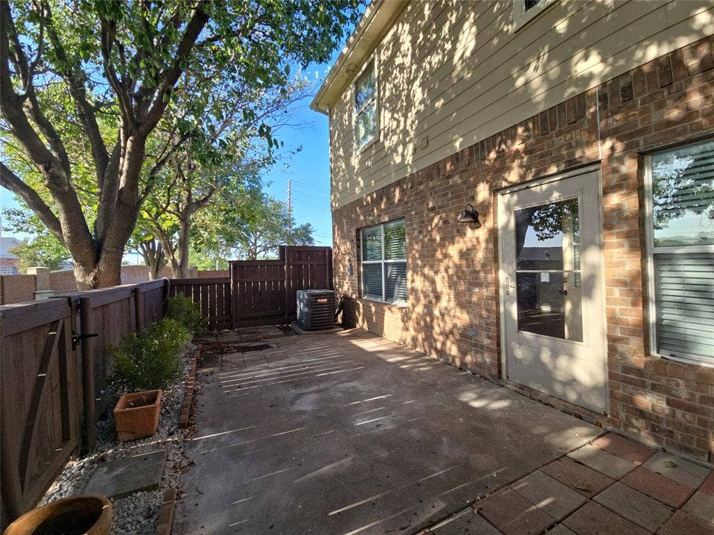 8621 Brunswick Drive, Plano, TX 75024 Private patio with wood fencing, brick and siding exterior, and mature trees