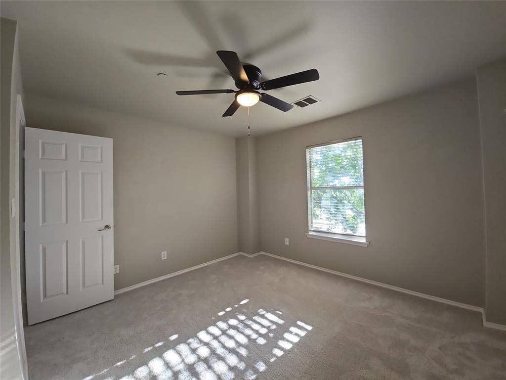 8621 Brunswick Drive, Plano, TX 75024 Neutral wall paint, light-toned carpet, ceiling fan with integrated lighting, window with blinds, six-panel interior door